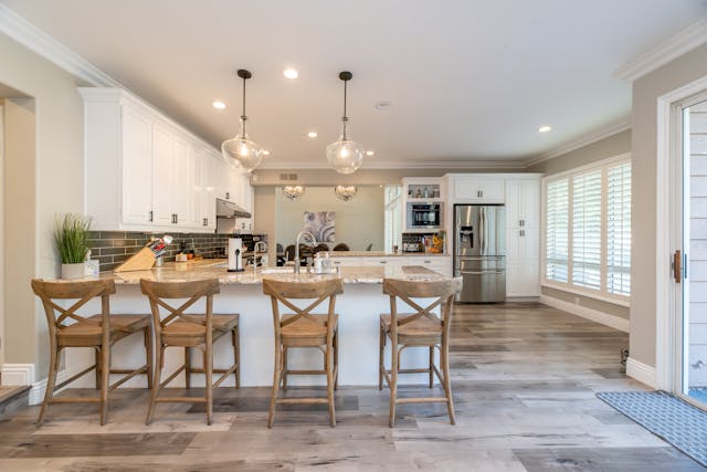 A kitchen with white cabinets and beige granite counters